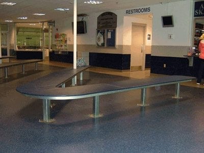 curved pedestal-mount table in lobby of arena